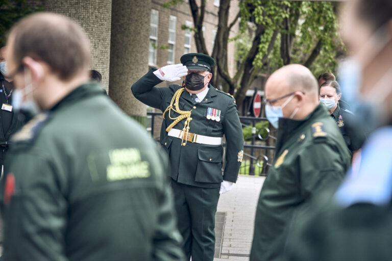A member of the ceremonial unit salutes as staff observe a minute's silence