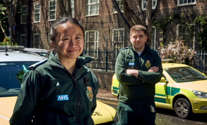 Two Emergency Responders in front of an ambulance vehicle.