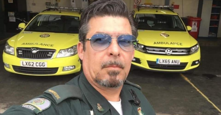 Brett photographed in uniform with two ambulance cars behind him