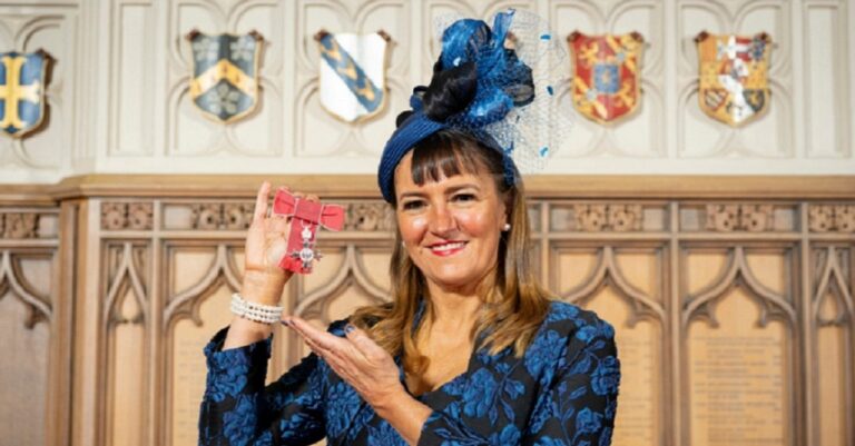 Amanda Mansfield holding her MBE inside Windsor Castle