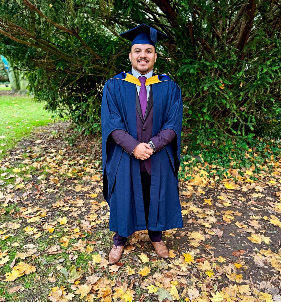Joshua wearing a university gown on his graduation day.