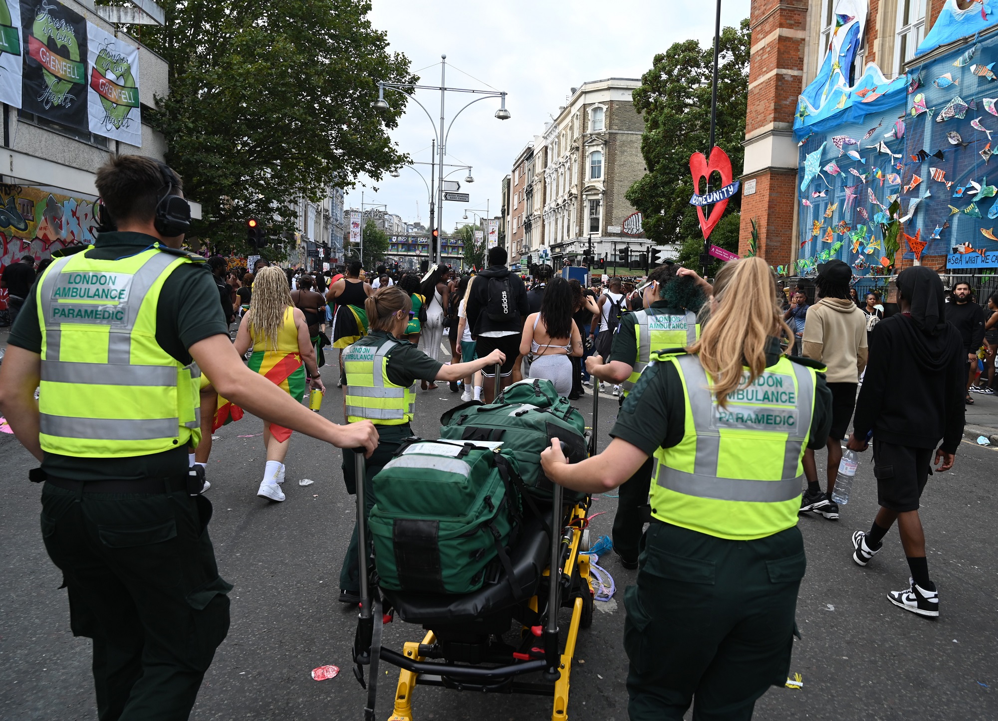 Paramedics at Notting Hill Carnival moving life-saving equipment through crowds.