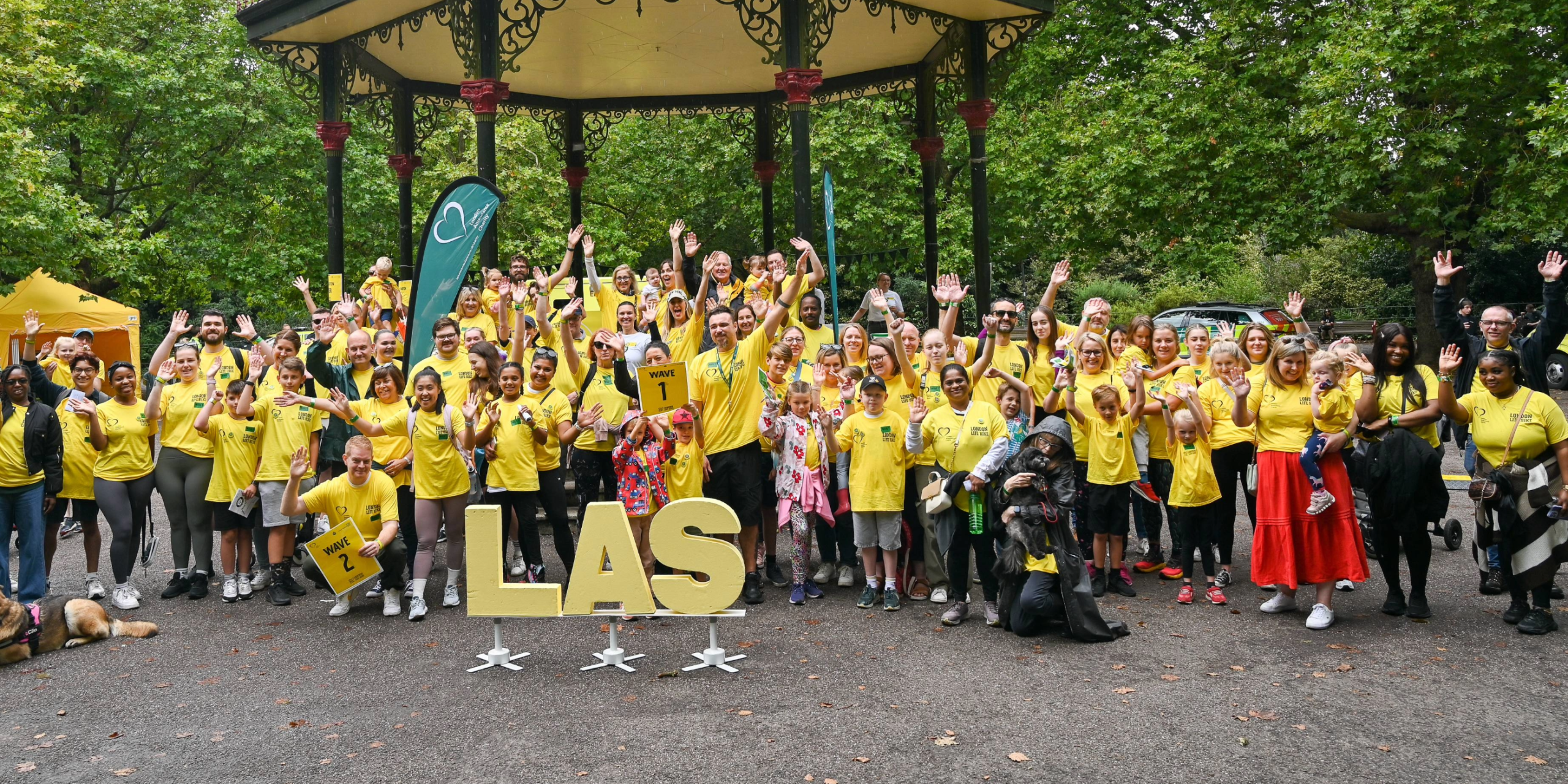 London Life Hikers pose for a group photo before the 2024 walking event starting at the Battersea Park Bandstand.