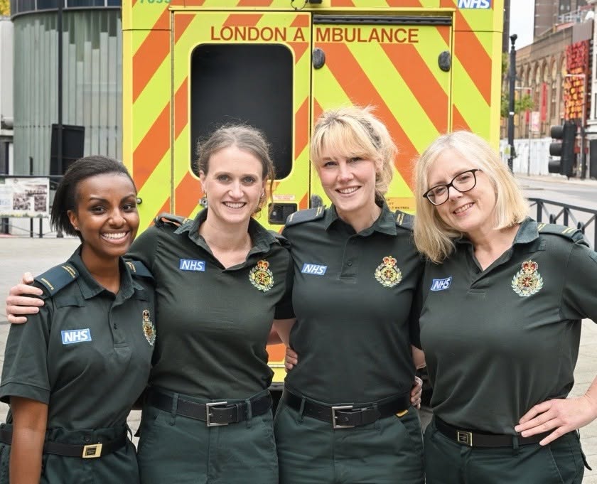 A photo of the maternity team in front of an ambulance.