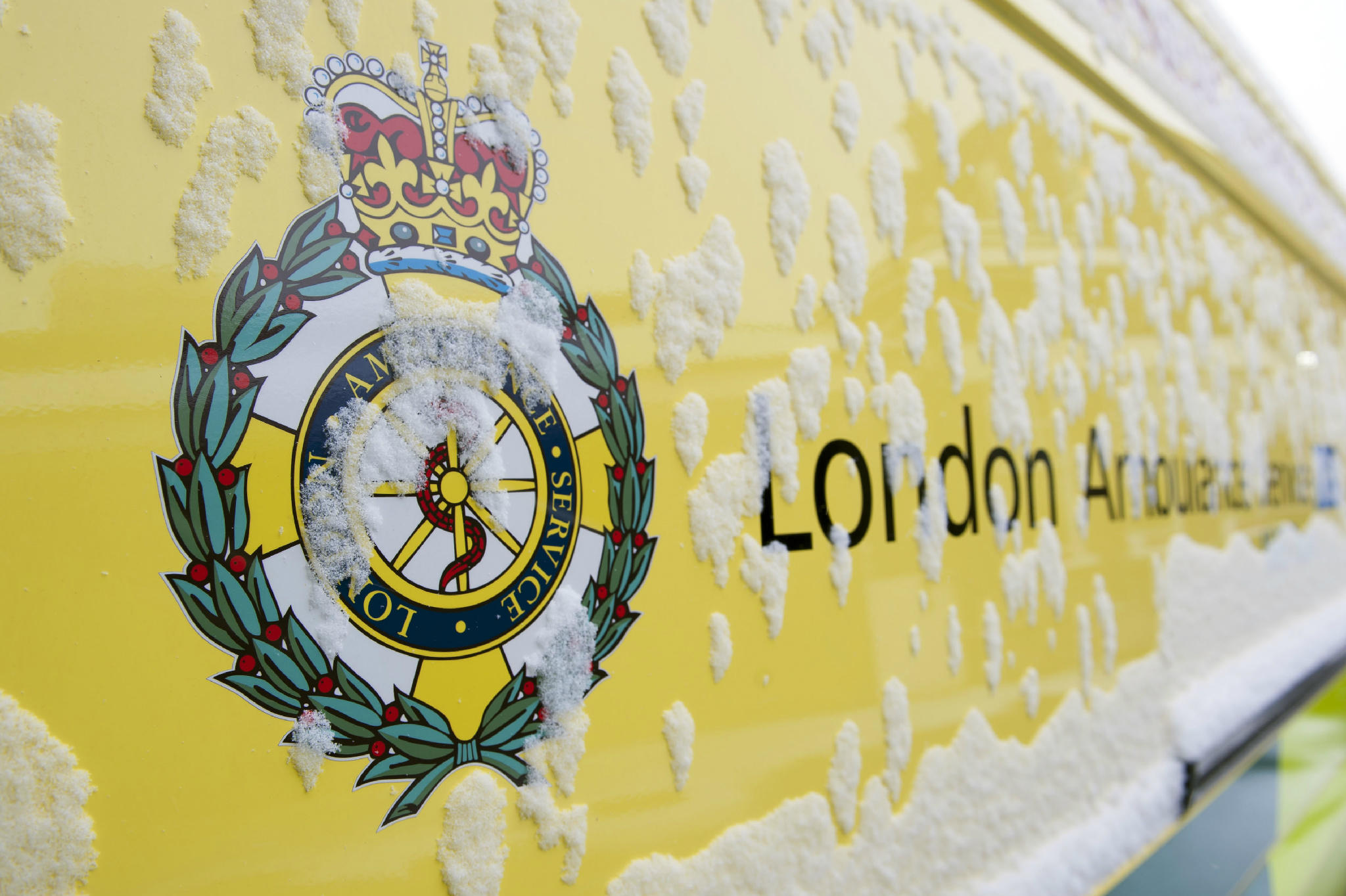 An ambulance with snow and ice on it's side