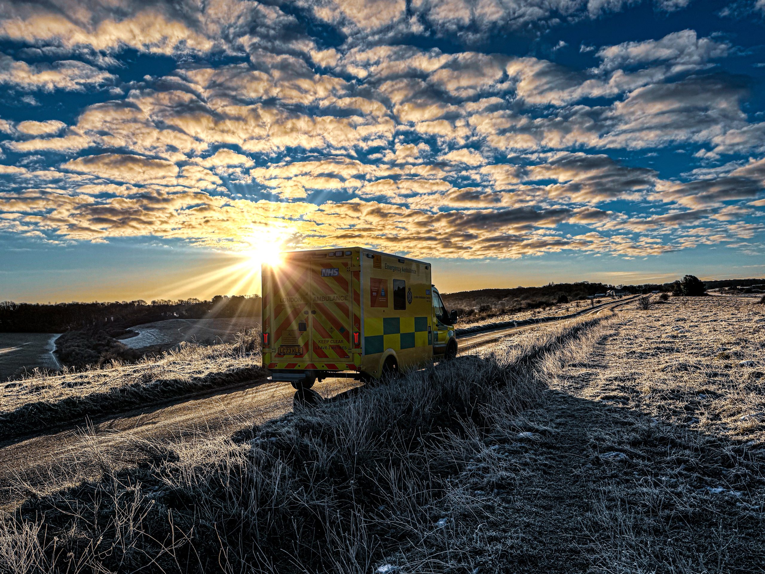Ambulance on an icy road in a park.