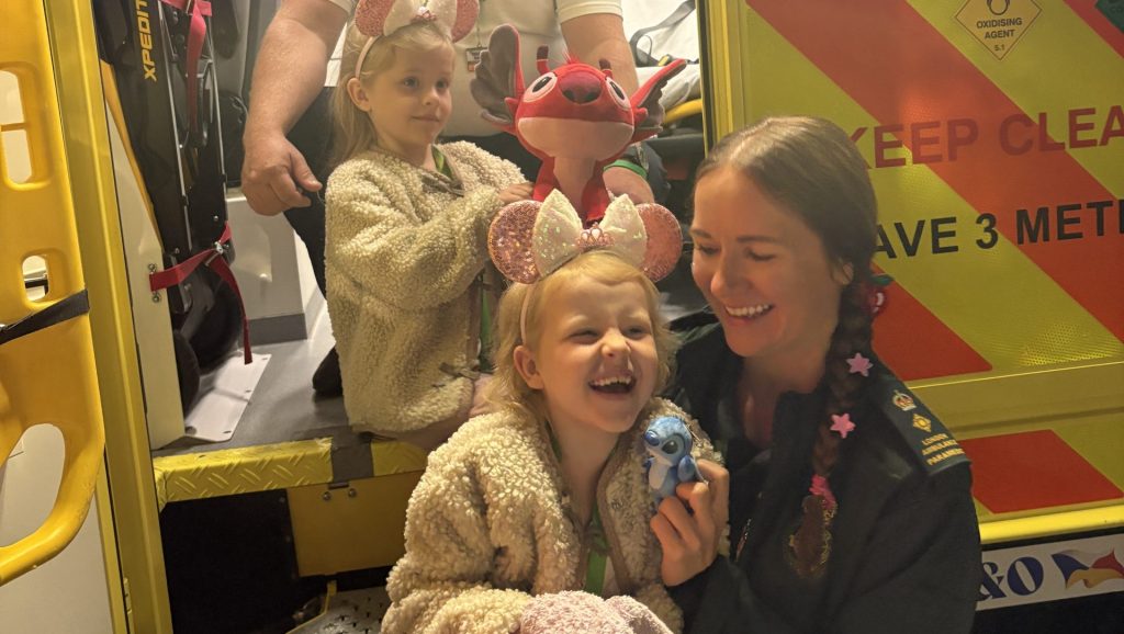 Children wearing Mickey ears laughing with paramedics