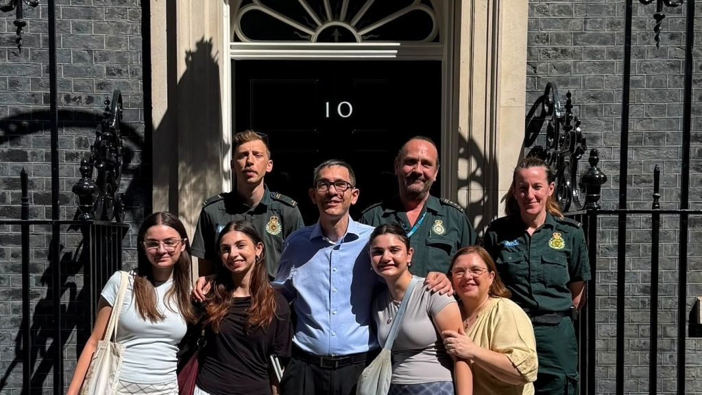 Patient Victor with family and paramedic crew standing in front of 10 Downing Street